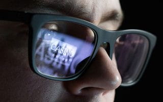 Casino Logo Reflection on a Man’s Glasses