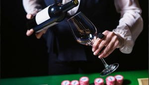 Casino Restaurant Staff Pooring Wine Over a Casino Table 