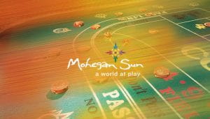 Mohegan Sun Casino Logo Over a Gambling Table with Chips on It