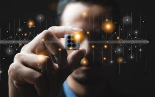 A Gambler Holding a Dice Infront of His Eyes