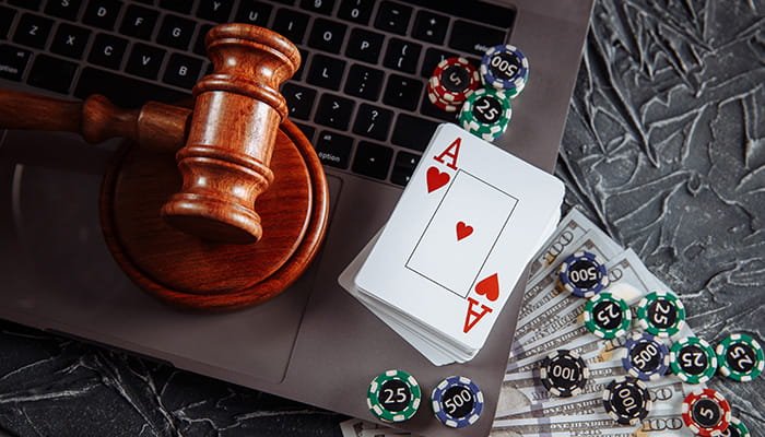 A Gavel on a Laptop with Dollar Bills and Casino Elements Spread Around It 