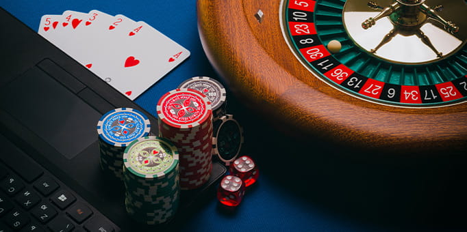 A Laptop and Casino Equipment on a Blue Surface